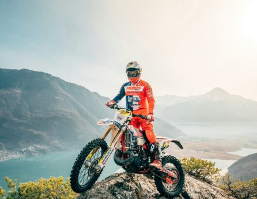 The image of the person with motocycle on the cliff